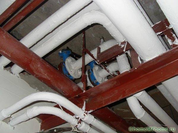 Окрашенные водопроводные трубы в подвале дома
